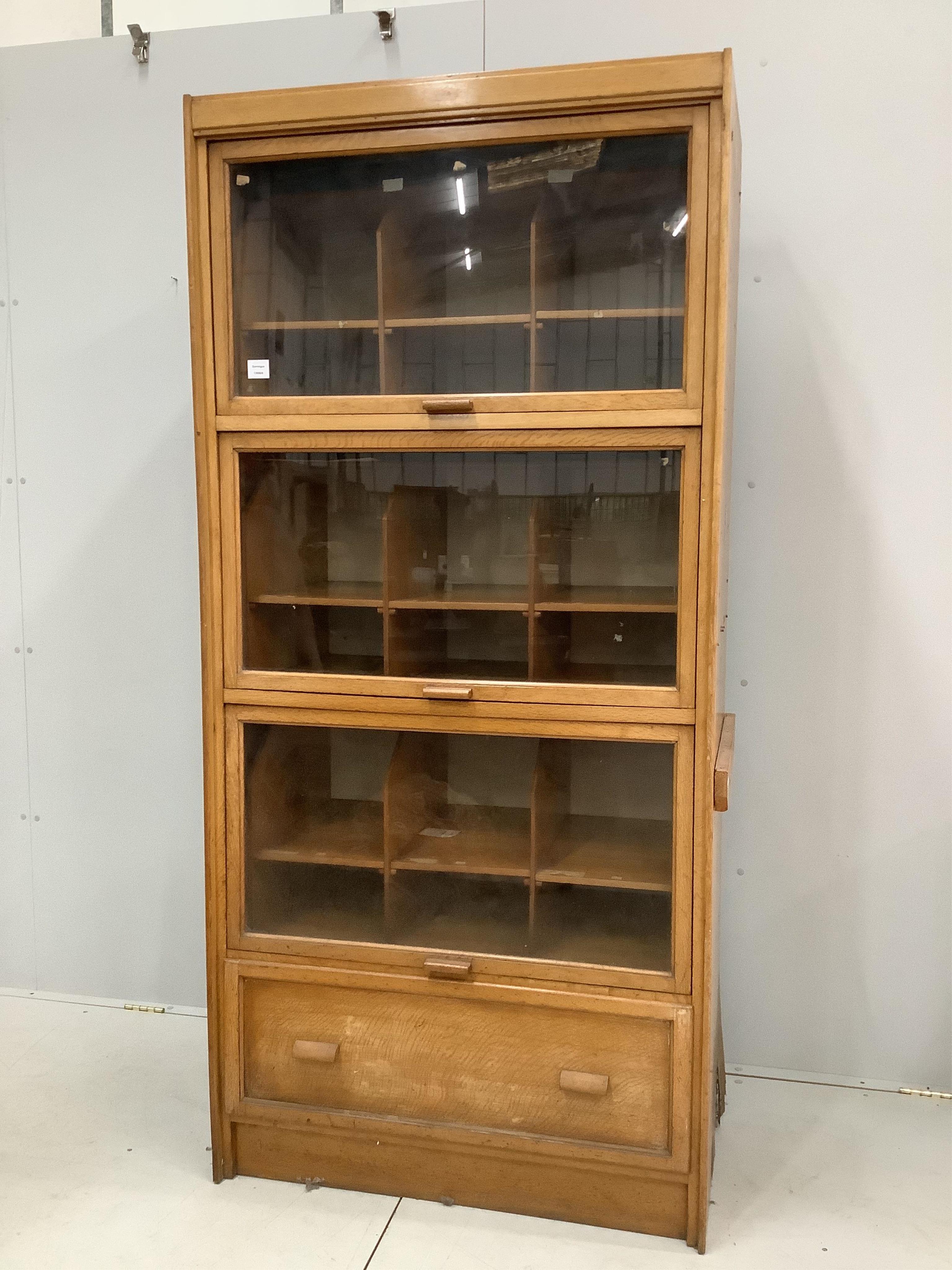 A mid century glazed oak haberdasher's cabinet, width 92cm, depth 50cm, height 198cm. Condition - fair